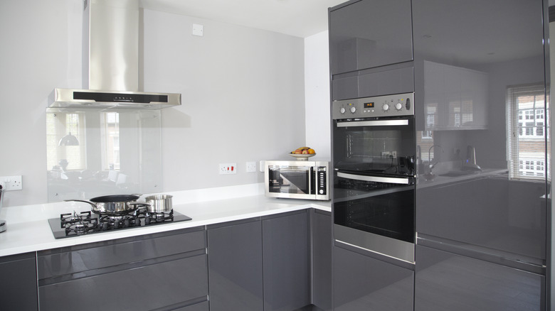 Minimalist bir mutfakta gri parlak dolaplar