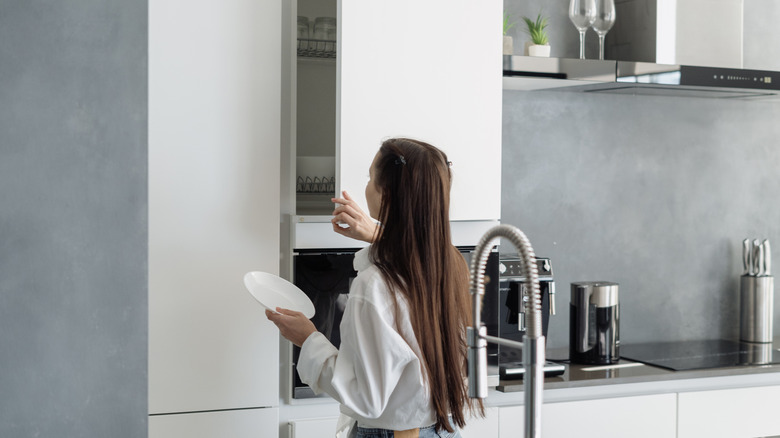 Nötr miniam liste mutfağında bir dolap açan bir kız