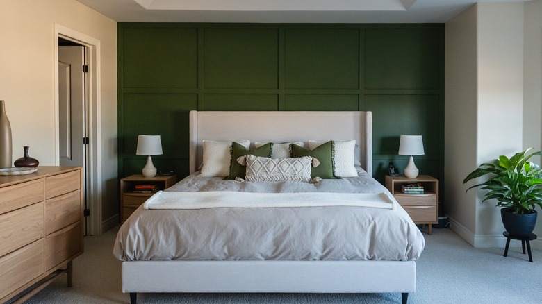 Gri yataklarla yatağın arkasında yeşil vurgu duvarı