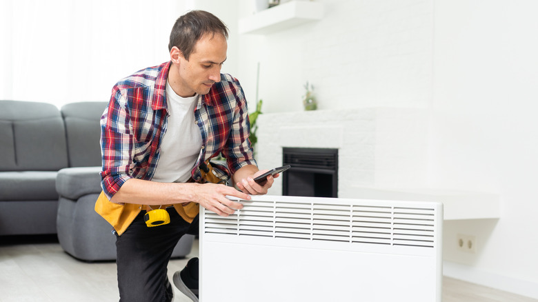 Bir radyatör tutan bir kişi, montajından çıkarıldı