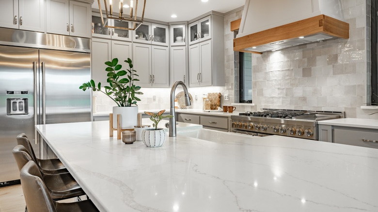 Büyük bir ada ve kuvars tezgahlı lüks bir mutfak