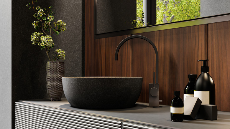 Siyah sabun dağıtıcıları ve lavabolu banyo tezgahı