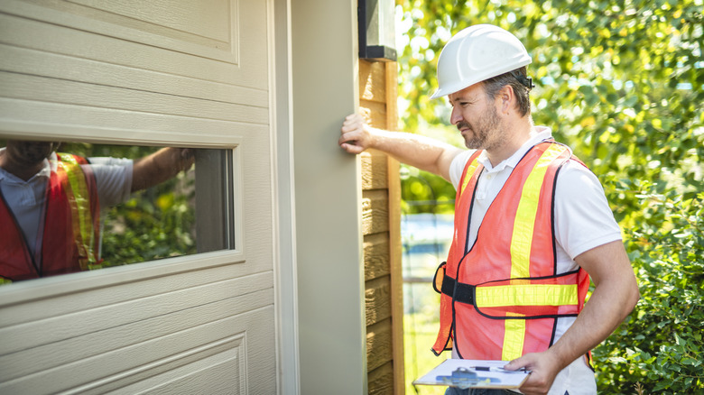 Garaj kapısını inceleyen bir adam
