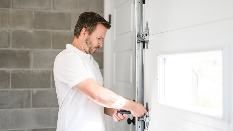 Garaj kapısını tamir eden bir adam