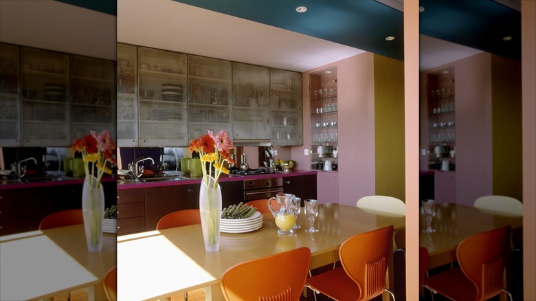 Terracotta sandalyeleriyle eşleştirilmiş pembe mutfak dolapları