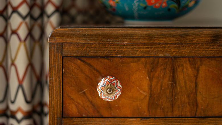 Ahşap bir çekmecede renkli bir seramik düğmesi