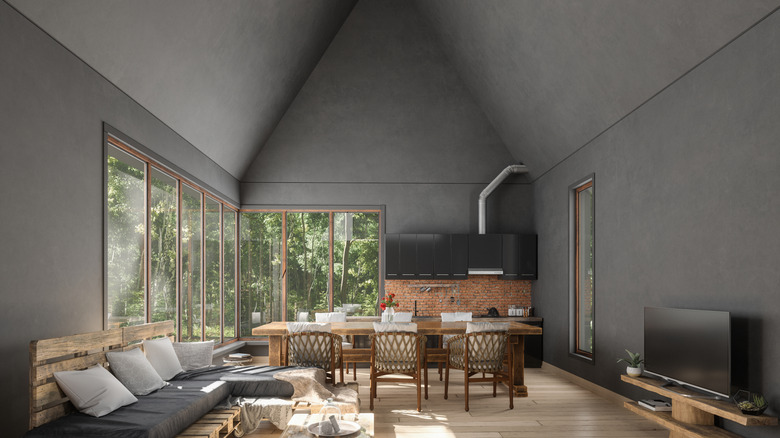 Monokromatik bir koyu gri ile boyanmış yüksek, tonozlu tavanlara sahip karamsar bir güneş odası.