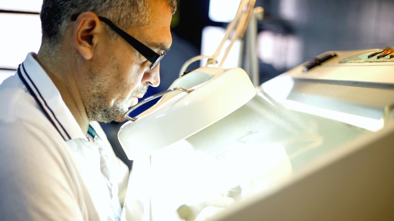 Büyük bir büyüteç ile sanat eserlerini değerlendirme