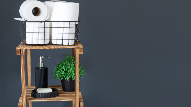 Tuvalet kağıdı ruloları bitki standında sepette