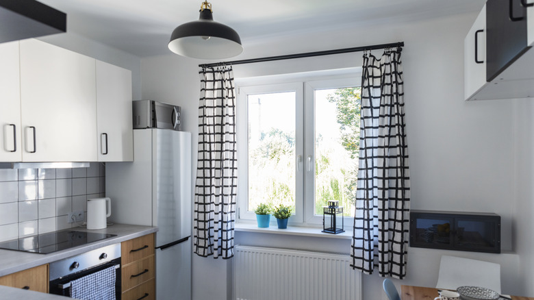 Siyah beyaz damalı perdelerle güncellenmiş bir mutfak