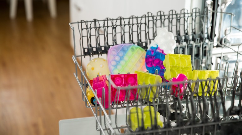 Yıkamak için bulaşık makinesinde sıraya dizilmiş oyuncaklar.