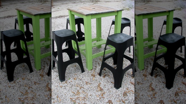 Bezelye çakıl verandasında küçük bir masa ve plastik tabureler