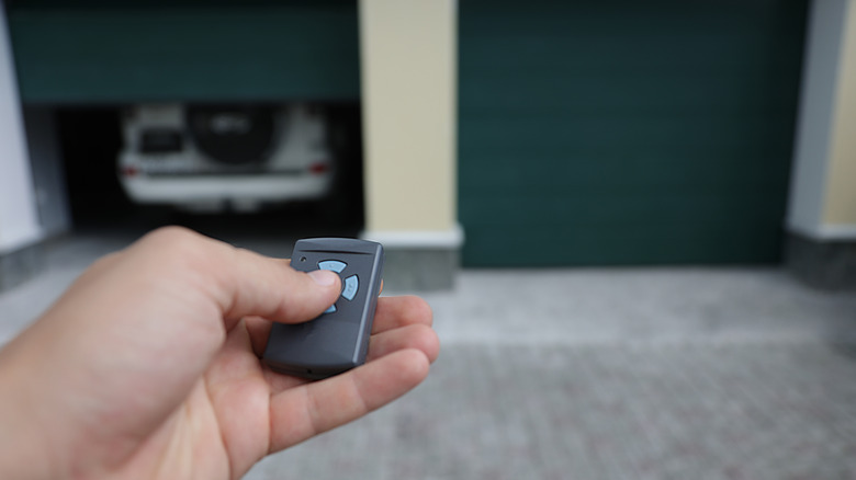 Garaj kapısı açıcısında bir düğmeye basan kişi