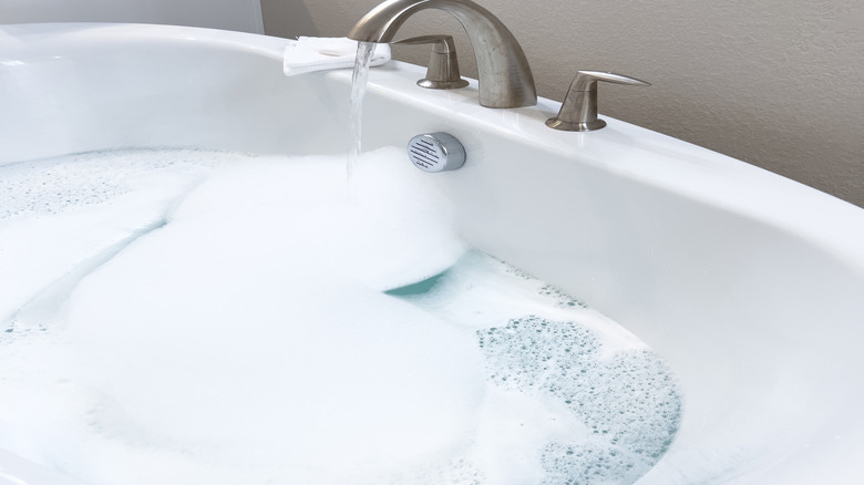 Fırçalanmış nikel musluk ile beyaz küvet