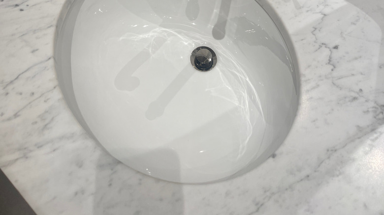 Cilalı bir nikel musluğu ile mermer lavabo