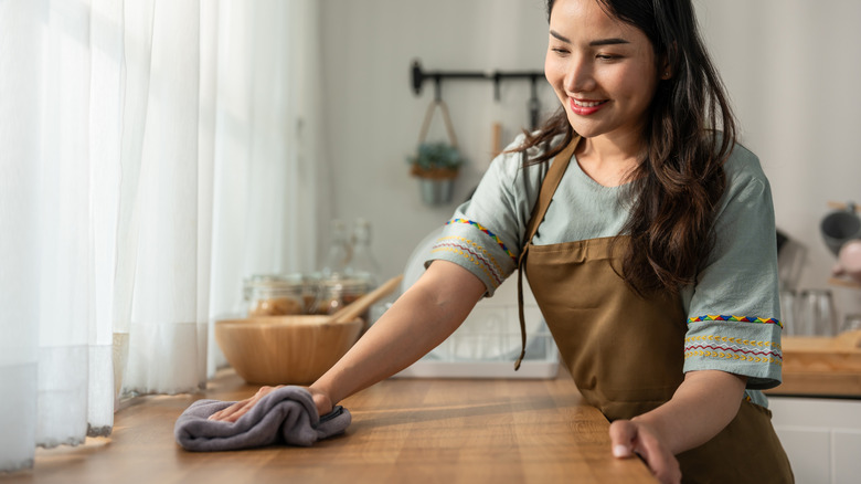 Tezgahı kumaşla siliyor kadın