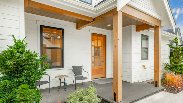 Ön kapının üzerine oturma alanı ve ahşap kirişli bir ön sundurma