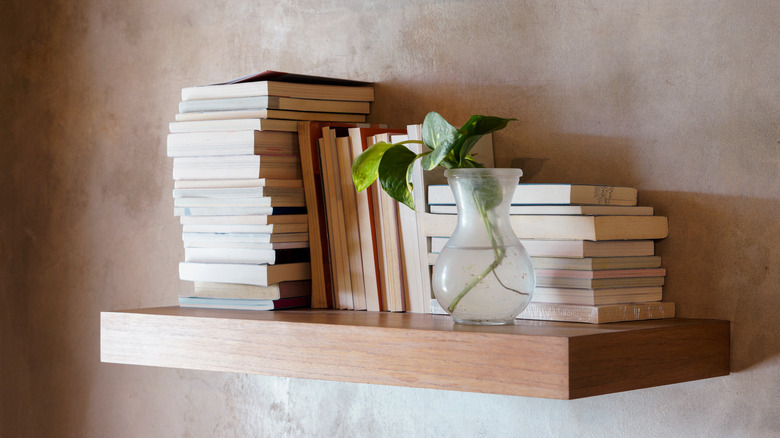 Kitaplar yüzen bir ahşap rafta istiflenmiştir