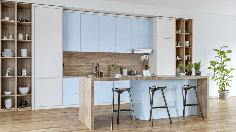 Açık mavi dolapları ve açık mavi mutfak adası olan modern bir mutfak