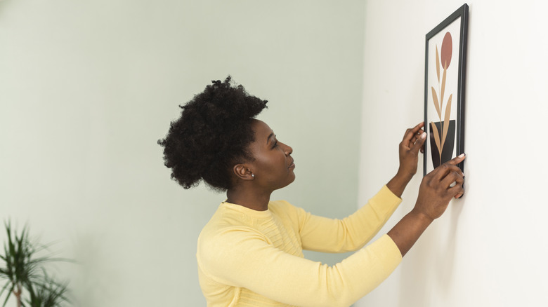 Bir kadın banyosuna sanat eseri asıyor