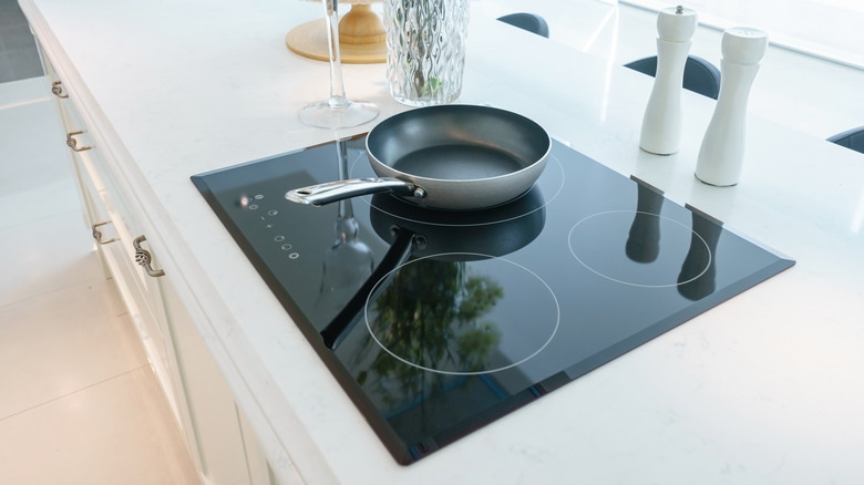 Temiz mutfakta cam soba üzerinde oturan tava tava