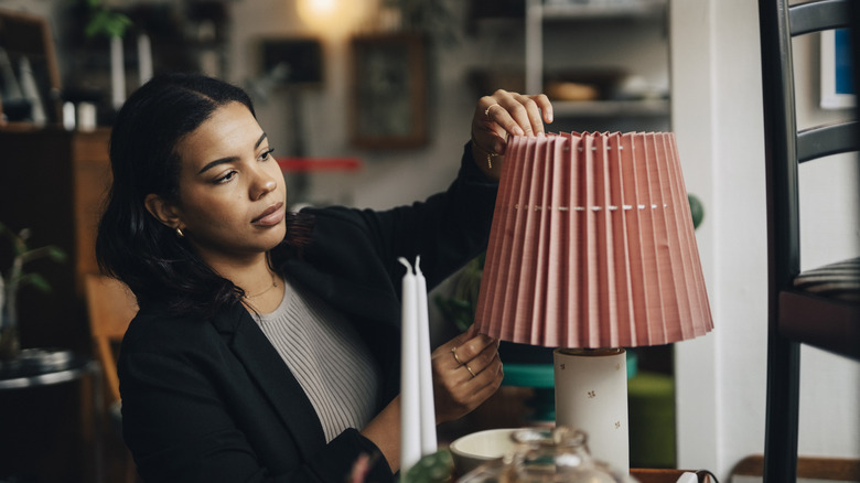 Oldukça vintage bir abajur ayarlayan kadın