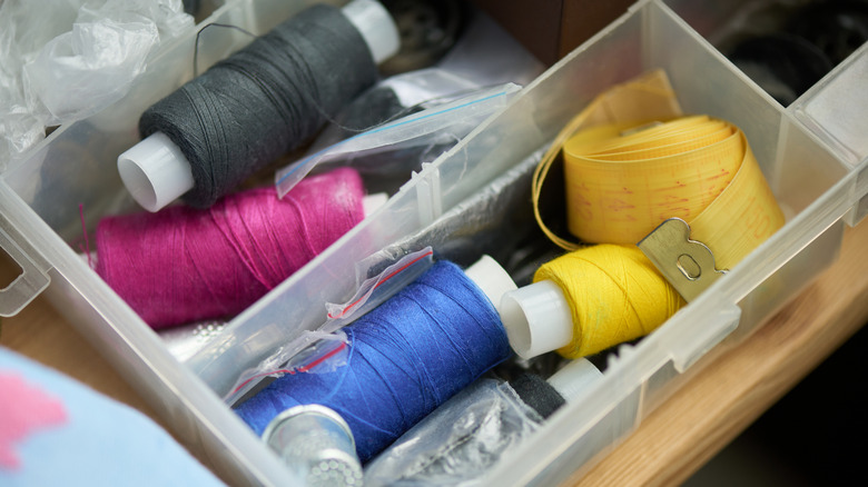 Tasarruf mağazasında plastik kaplarda dikiş malzemeleri