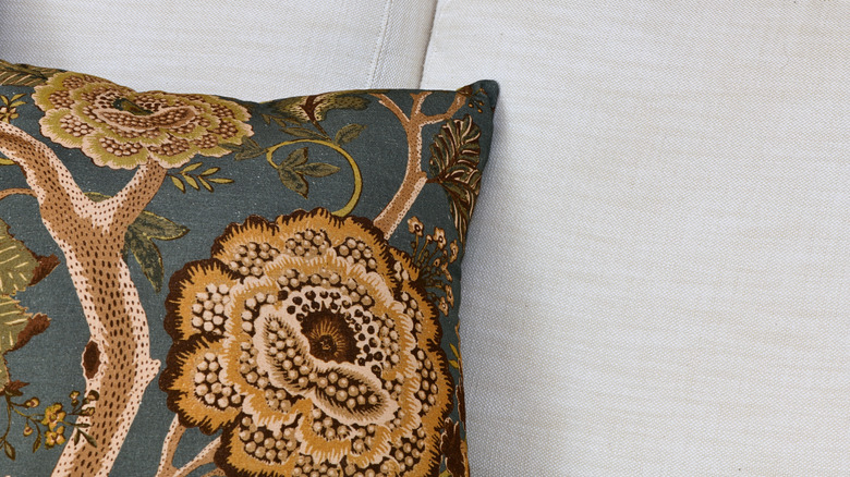 Düz kanepede nakış malzemesi ile yapılmış yastık atın