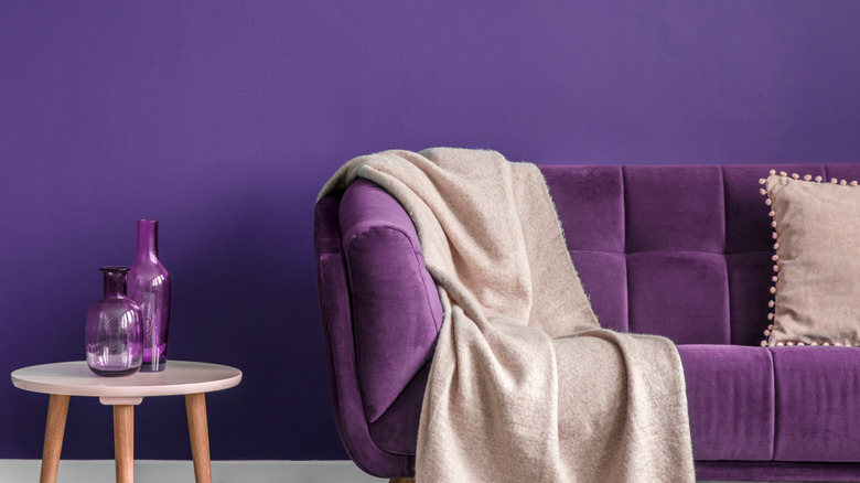 Mor duvarları, mor dekor ve mor kanepeli tek renkli oturma odası