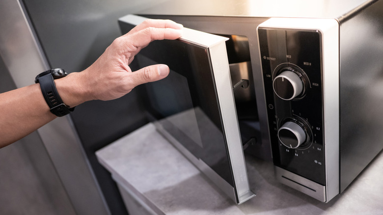 Showroom'da mikrodalga fırını denetleyen kişi