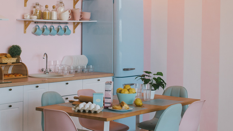 Soluk pembe duvarlar ve mavi retro buzdolablı mutfak
