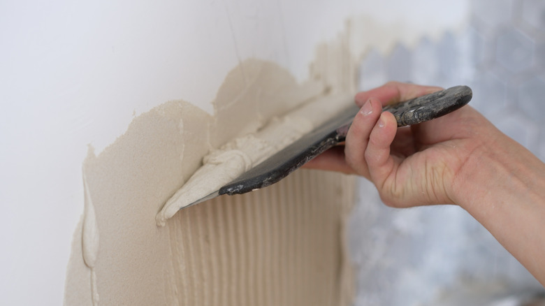 Kiremit kurulumu için mala kullanarak bir duvara yapıştırıcı uygulama