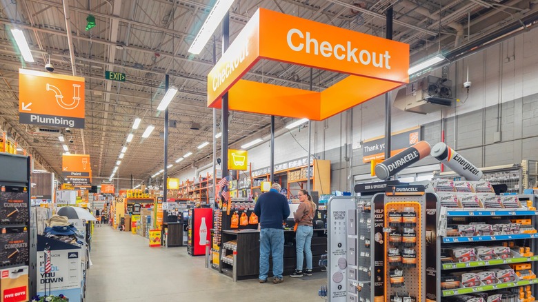 Home Depot Müşterileri 'Ödeme' okuma büyük bir turuncu işaretin altında duruyor