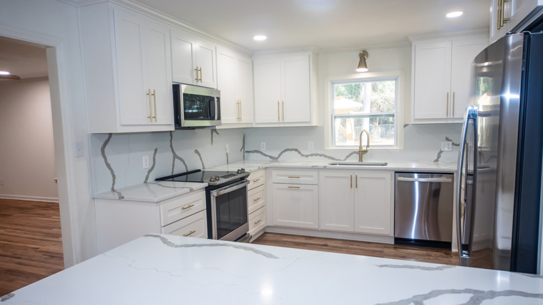 Kuvars tezgahlı yeni yenilenmiş beyaz mutfak