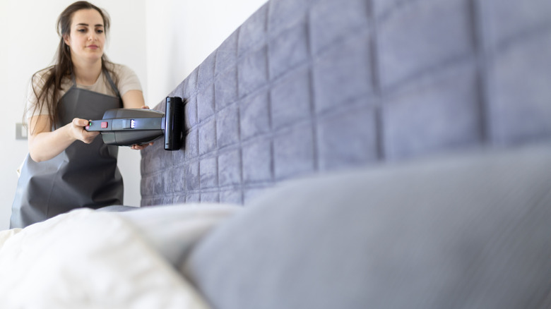 Kadife kaplı bir başlık vakumlayan bir kişi