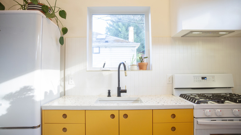 Sarı dolapları ve kremalı duvarlı mutfak