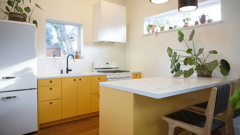 Küçük modern mutfakta iki farklı sarı dolap