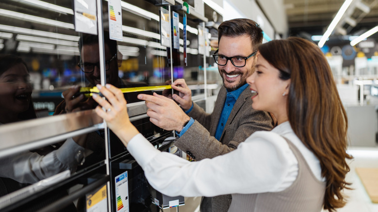 Bir cihaza bakan ve ölçen iki kişi.