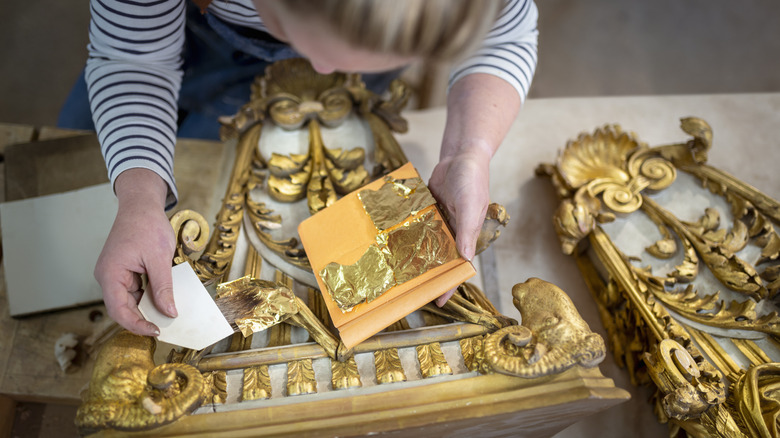 Tepegöz atış, yaldızlı dekoratif unsurlara altın yaprak uygulayan bir kadını gösterir