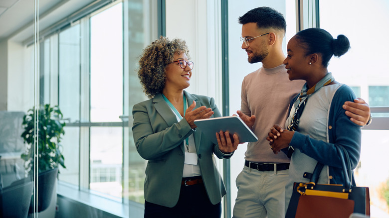 Genç çift bir tablet tutan bir profesyonelle konuşuyor