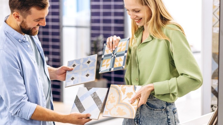 Mavi ve beyaz mozaik karo ve koi balık deseni duvar kağıdı ile eklektik banyo