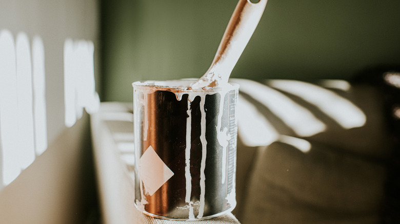 Güneşli odada taze boyalı duvarlar tarafından bir kutu boya