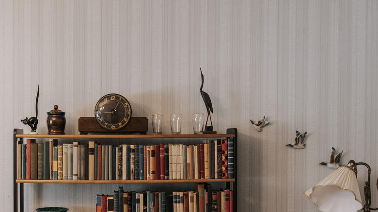 Üstte ve duvarda hayvan heykelleri olan raf