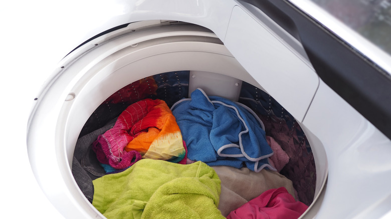 Beyaz çamaşır makinesinin en iyi görünümü, temizlik için içine yüklü giysiler.