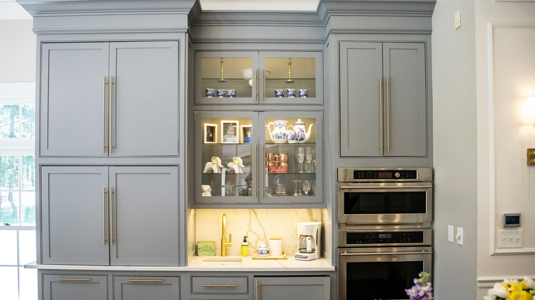 Dahili aydınlatma içeren iki cam dolap ekran kasası ile mutfak