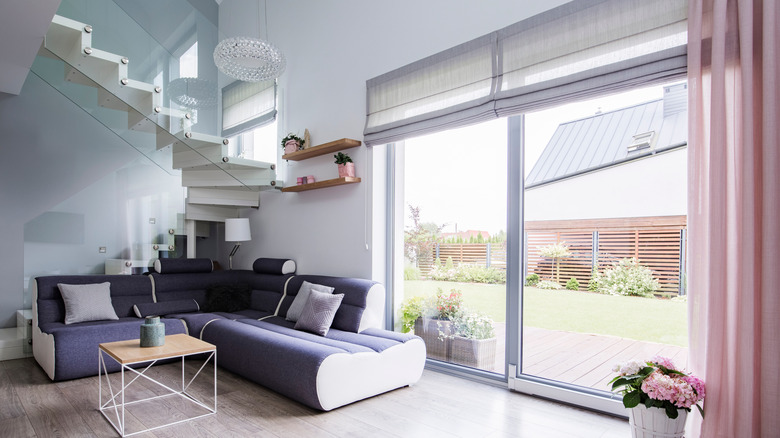 Modern oturma odasında sürgülü cam kapı üzerinde Roma katlanır panjurlar