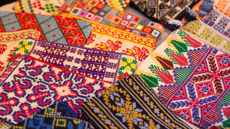 Otantikliği ve modernliği harmanlayan sanatsal bir el sanatları atölyesinde masada sergilenen birden fazla tasarım ve renkte zarif el nakışları