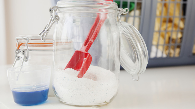 Yanında bir fincan sıvı temizleyici ile temiz kavanozda çamaşır deterjanı