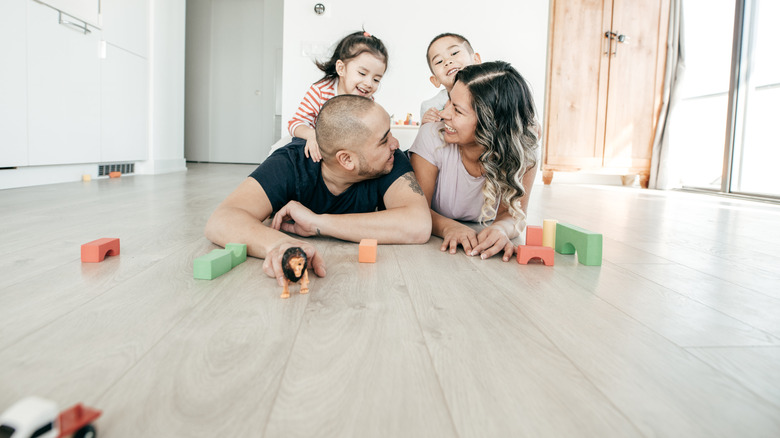 Dört kişilik bir aile, lüks bir vinil katta oyuncaklarla oynar.