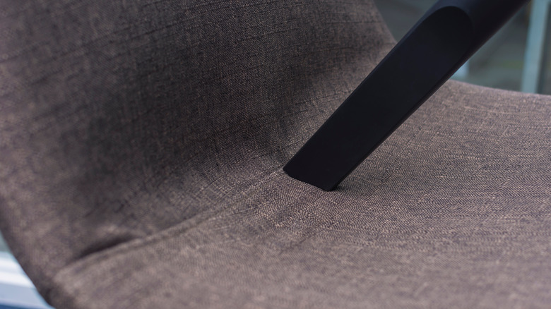 Döşemeli bir sandalyeye bastırılmış bir vakum nozeri